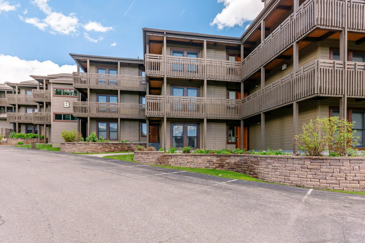 Another exterior view, this image captures stylish balconies, attractive stonework, and landscaped outdoor areas. The scene hints at socializing outdoors, morning coffee, and evening strolls—extending the sense of leisure and vibrancy tied to après-ski and dining adventures.